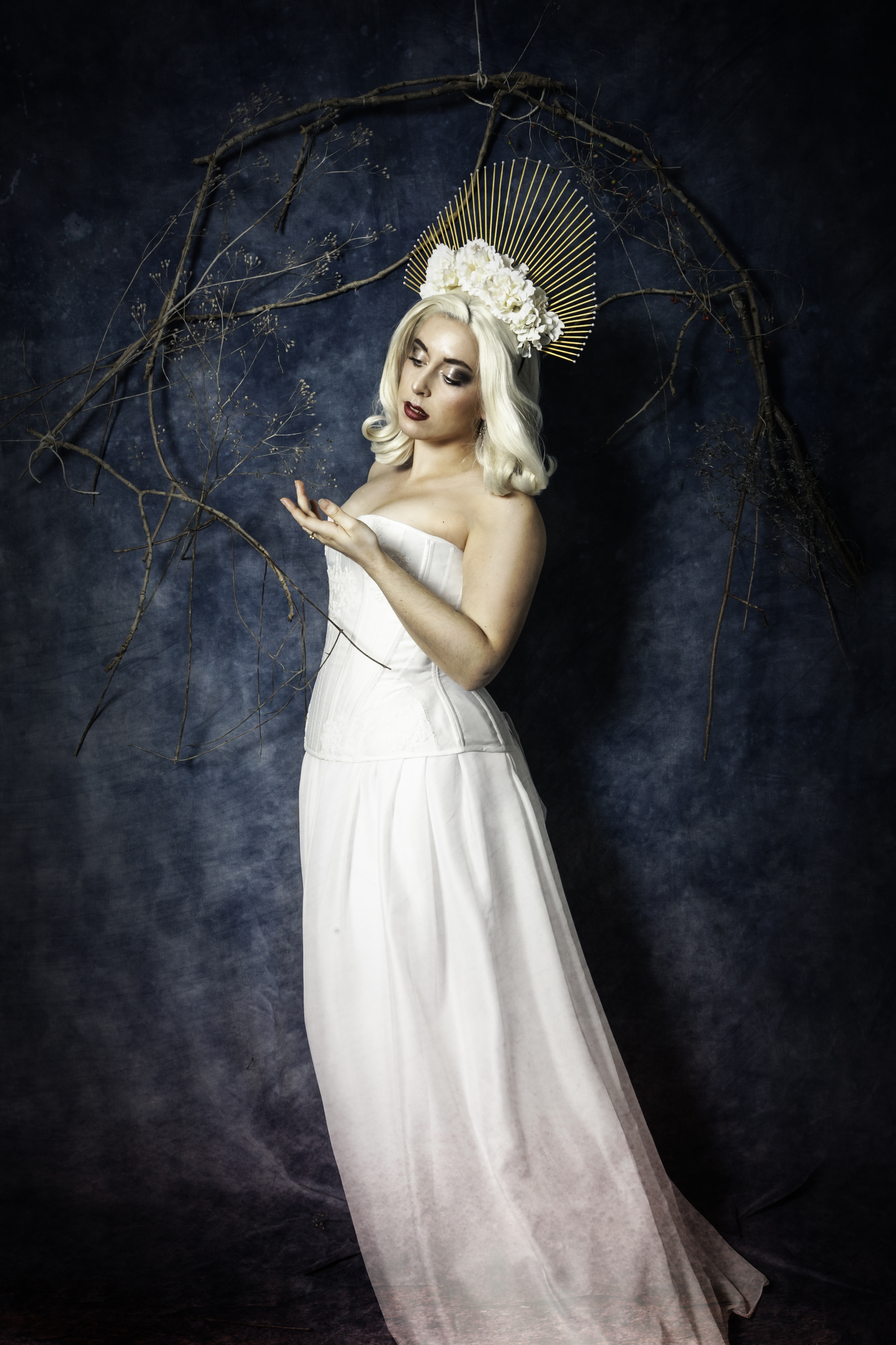 Corset blanc et dentelle, coiffe dorée, fleurs et perles blanches.